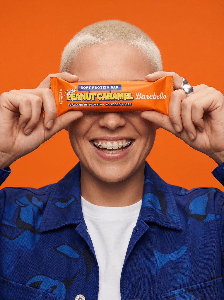 Man holding a protein bar over his eyes